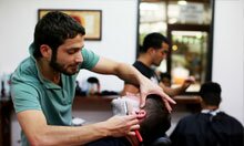 A man receiving a shave at a barbers. 